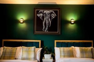 um quarto com duas camas e uma foto de um elefante em Lomond Park Hotel em Balloch