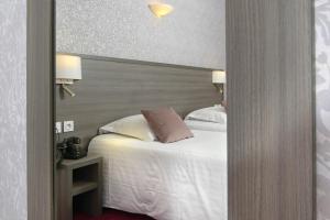 Cama ou camas em um quarto em Hôtel De France