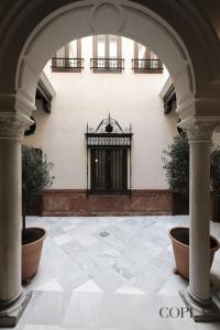 un arco en el patio de un edificio con una puerta en Premium Apartment with Rooftop in Centro Sevilla, en Sevilla