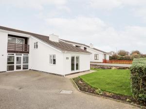 a white house with a driveway at Llwyn Eithin in Holyhead