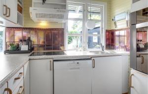 uma cozinha com armários brancos, um lavatório e uma janela em Beautiful Home In Lgstrup With Outdoor Swimming Pool em Løgstrup