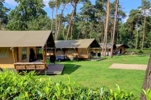 um grupo de chalés na floresta em Familiepark Goolderheide em Bocholt