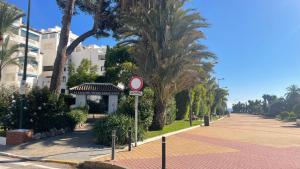 una calle con palmeras y una señal de no estacionamiento en Playa Del Duque Apartment Ocean Club 1, en Marbella