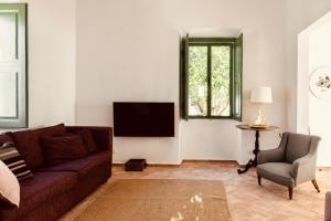 sala de estar con sofá y TV en Casa Dona Antonia, en São Bartolomeu de Messines