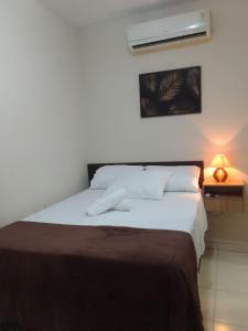 sypialnia z białym łóżkiem i brązowym kocem w obiekcie Chalé Brisas do Rio w mieście Petrolina