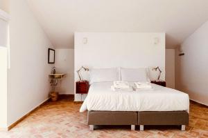 1 dormitorio con 1 cama grande con sábanas blancas en Casa Dona Antonia, en São Bartolomeu de Messines