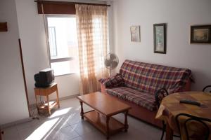 sala de estar con sofá y mesa en Apartamentos Muro, Juana & Charca, en Conil de la Frontera