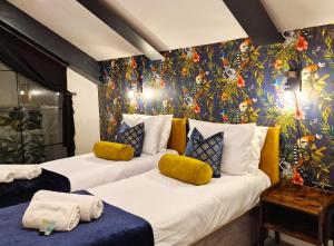 2 camas en una habitación con una pared floral en The Academy House by Bevolve, en Shrewsbury