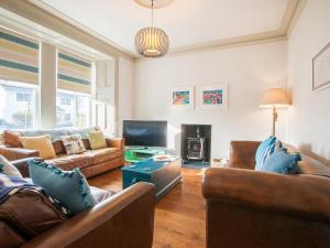 a living room with couches and a fire place at Anya in Morfa Nefyn