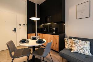 ein Wohnzimmer mit einem Tisch und Stühlen sowie eine Küche in der Unterkunft 2Homerent Shellter 117 in Rogowo