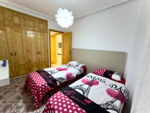 2 Einzelbetten in einem Zimmer mit Kronleuchter in der Unterkunft Modern Apartment On Playa Del Cura in Torrevieja