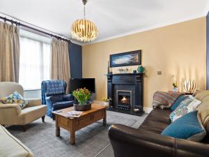 a living room with a couch and a fireplace at New Cross House in St. Davids