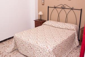 コニル・デ・ラ・フロンテーラにあるApartamentos Muro, Juana & Charcaのベッドルーム1室(模様入りの毛布付きのベッド1台付)