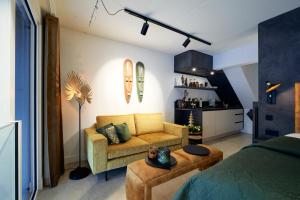 Cette chambre comprend un lit, un canapé et une table. dans l'établissement Nomad Water Studio, à Harderwijk