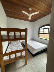 two bunk beds in a room with a ceiling at Hostel Bike Point Caraguatatuba in Caraguatatuba