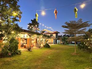 een tuin met kerstverlichting die aan een huis hangt bij Nadoiview Homestay นาดอยวิวโฮมสเตย์ in Pua