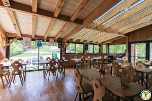 a restaurant with wooden ceilings and tables and chairs at Auberge La Soulan in Boutx