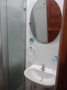 La salle de bains est pourvue d'un lavabo et d'un miroir. dans l'établissement Hostal Ostello Amadeus, à Arica