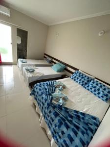 dwa łóżka w pokoju niebiesko-białym w obiekcie APARTAMENTO 104- BGMC w mieście Guaibim