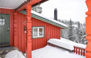 ein rotes Haus mit Schnee an der Außenseite in der Unterkunft Awesome Home In Eggedal With House A Mountain View in Eggedal