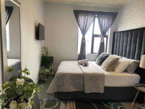 a bedroom with a bed and two windows at The Ark in Maboneng in Johannesburg