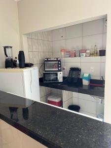 a kitchen with a counter top with a microwave at APARTAMENTO 104- BGMC in Guaibim