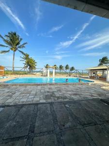 a large swimming pool with palm trees in the background at APARTAMENTO 104- BGMC in Guaibim