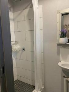 a white bathroom with a shower and a sink at The Ark in Maboneng in Johannesburg