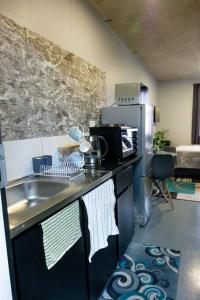 a kitchen with a sink and a refrigerator at The Ark in Maboneng in Johannesburg