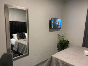 a bedroom with a mirror and a tv on the wall at The Ark in Maboneng in Johannesburg