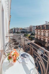 a table on a balcony with a view of a city at Boutique Hotel Palais Royal in Odesa