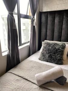a bedroom with a bed with a pillow and a window at The Ark in Maboneng in Johannesburg