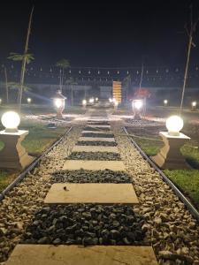 a walkway with lights on the tracks at night at استراحة دار العين in Al Ain