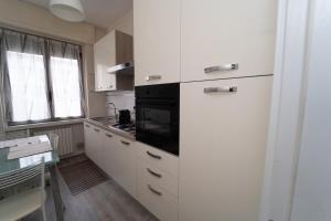 una cocina con armarios blancos y un aparato negro en Appartamento 2 vicino Milano, en Bresso