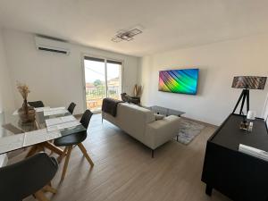 uma sala de estar com um sofá e uma mesa em Alivu - Appartement Moderne Avec Terrasse em Cargèse