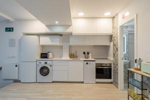 een keuken met witte kasten en een wasmachine en droger bij Bright new and wide- 1Bd 1Bth- Delicias in Madrid