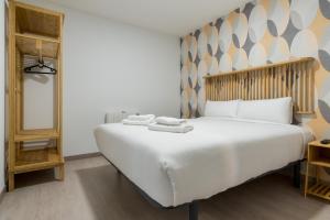 Bright new and wide- 1Bd 1Bth- Delicias في مدريد: غرفة نوم بسرير ابيض كبير عليها مناشف