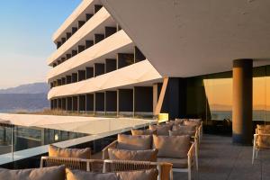 a building with a bunch of chairs in front of it at Grand Hotel View in Postira