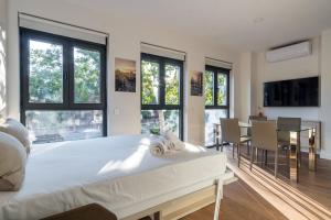 a bedroom with a large white bed and a dining room at Cozy studio - 1Bathroom - Salamanca in Madrid