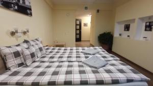 a bedroom with a large bed with a plaid blanket at Green Corner Wellness in Püspökladány