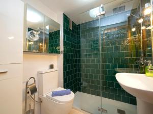 ein grün gefliestes Bad mit einem WC und einem Waschbecken in der Unterkunft Apartment Apolo III by Interhome in Calpe