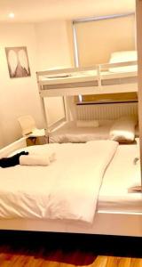 a bedroom with two bunk beds with white sheets at H3: Fantastic Apt - 100m from Piccadilly Circus!! in London