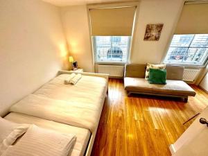 a small room with two beds and a couch at H3: Fantastic Apt - 100m from Piccadilly Circus!! in London