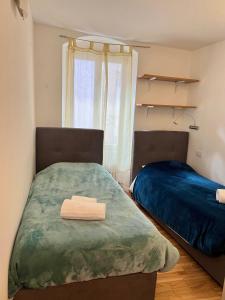 a bedroom with two beds and a window at Mazzini, 30 Nord in Rovereto