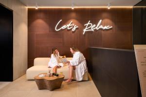 two women in white robes sitting on a couch at Grand Hotel View in Postira