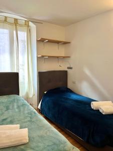 sypialnia z 2 łóżkami i oknem w obiekcie Mazzini, 30 Nord w mieście Rovereto