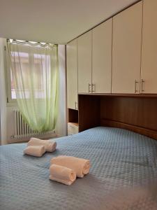 a bedroom with two towels on a bed with a window at Mazzini, 30 Nord in Rovereto