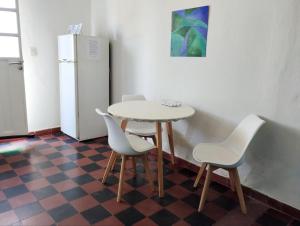 una mesa y sillas en una habitación con nevera en Hospedaje DCB en Capilla del Monte