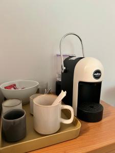 a counter with cups and a coffee maker on it at Mazzini, 30 Nord in Rovereto