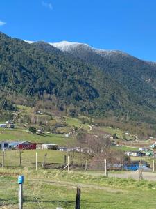 a view of a field with a mountain in the background at Cabaña lancuyen in Futrono